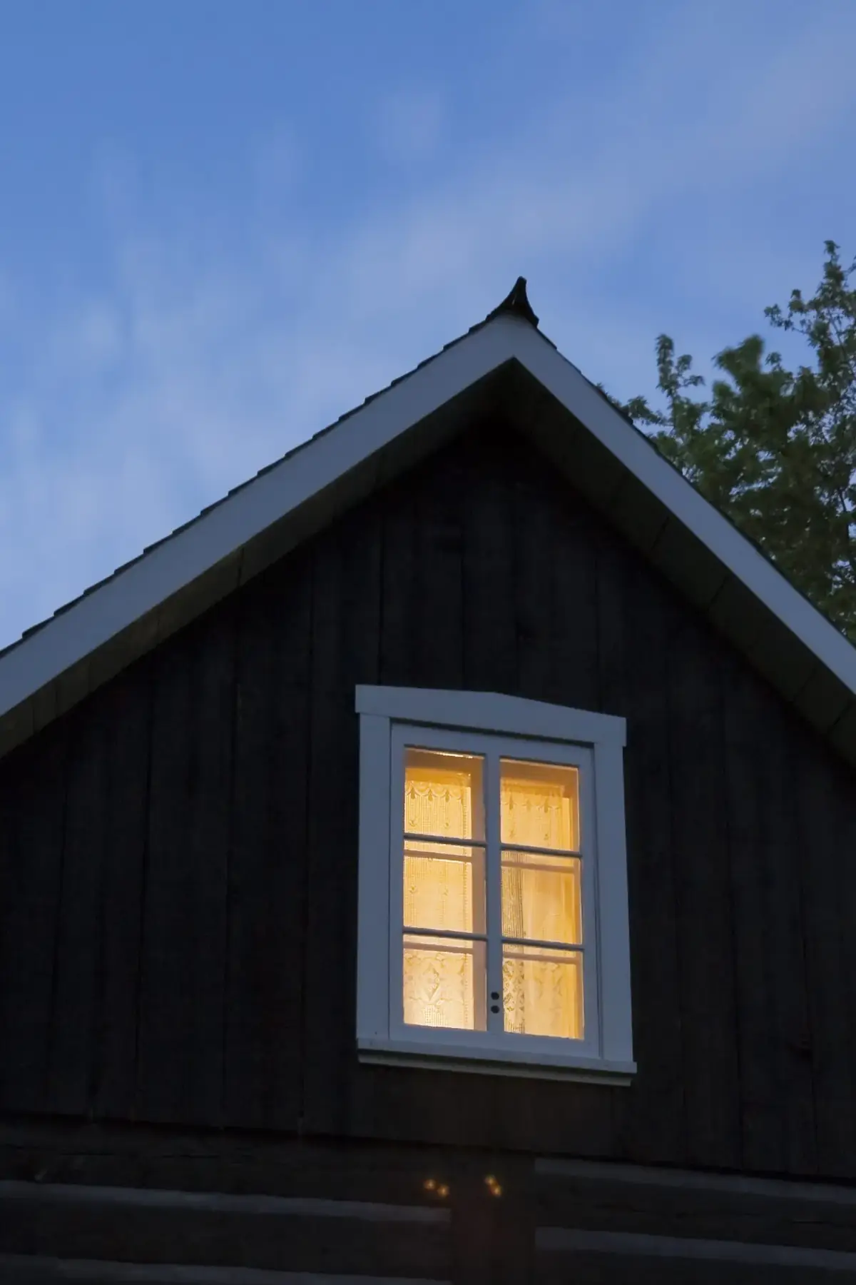 Villa med upplysta fönster i kvällsljus